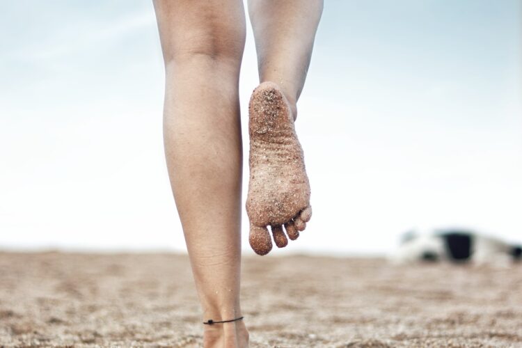 woman in brown stockings and brown boots standing on brown sand during daytime